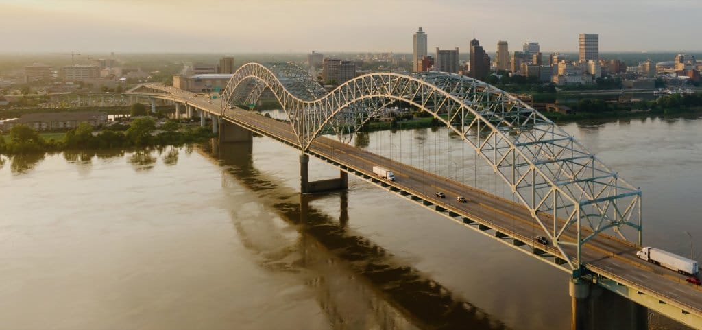 Aerial sunrise view of the Hernando de Soto Bridge and downtown Memphis across the Mississippi River.